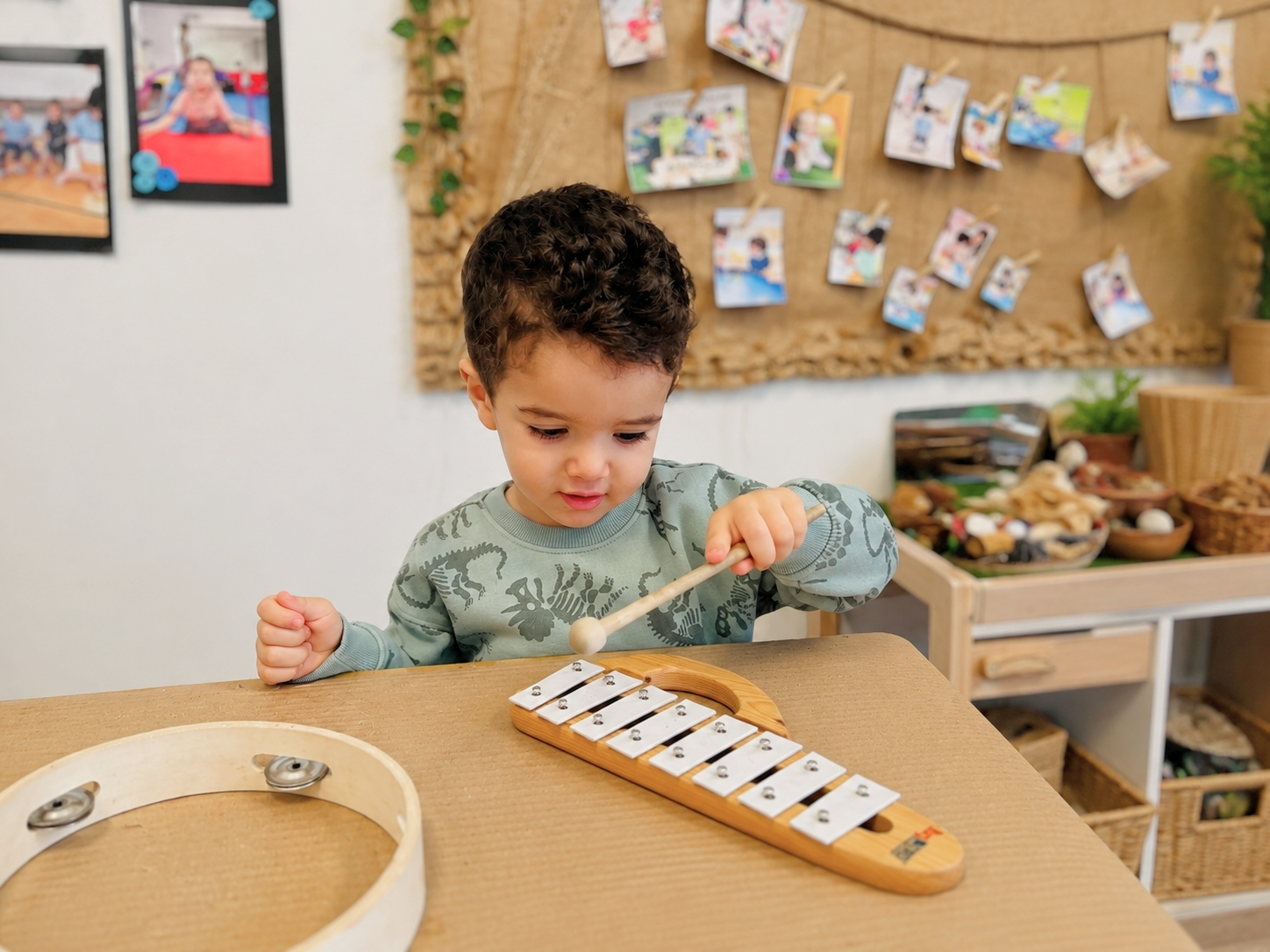Child exploring music and rhythm by playing a wooden xylophone at Discovery Nursery in Abu Dhabi