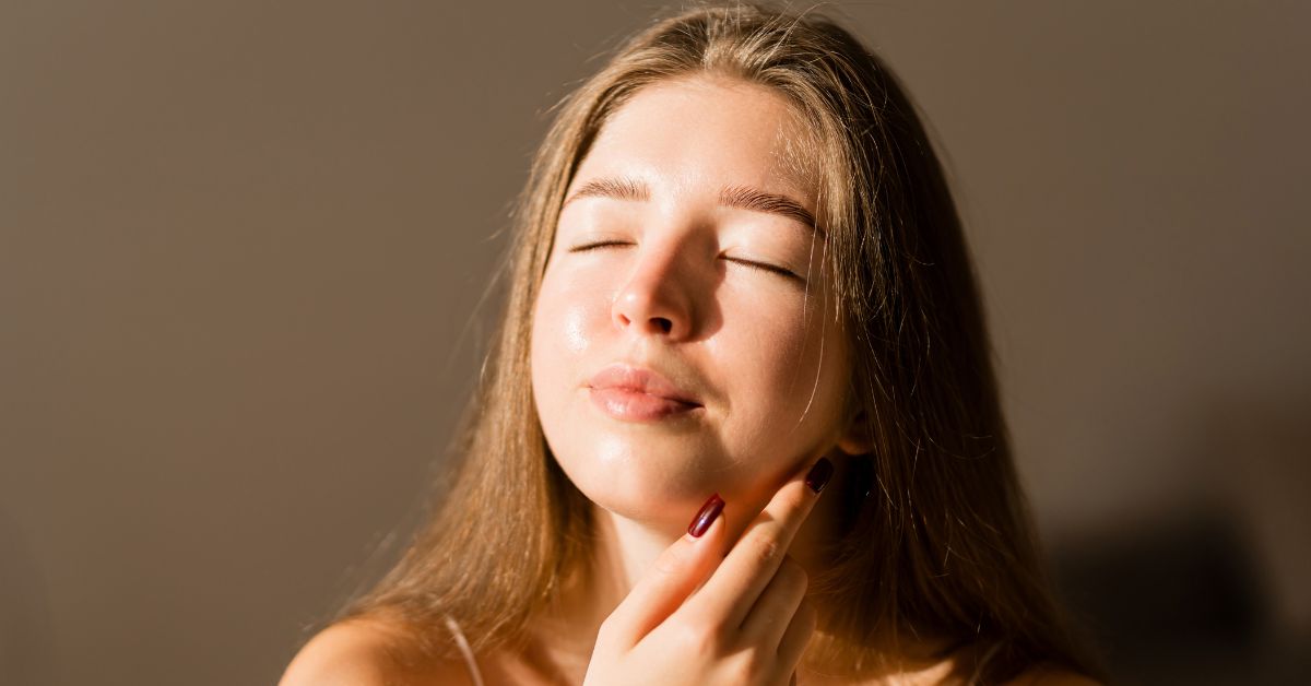 Woman with glowing healthy skin enjoying summer while maintaining aesthetic treatment results with proper skincare and sun protection.