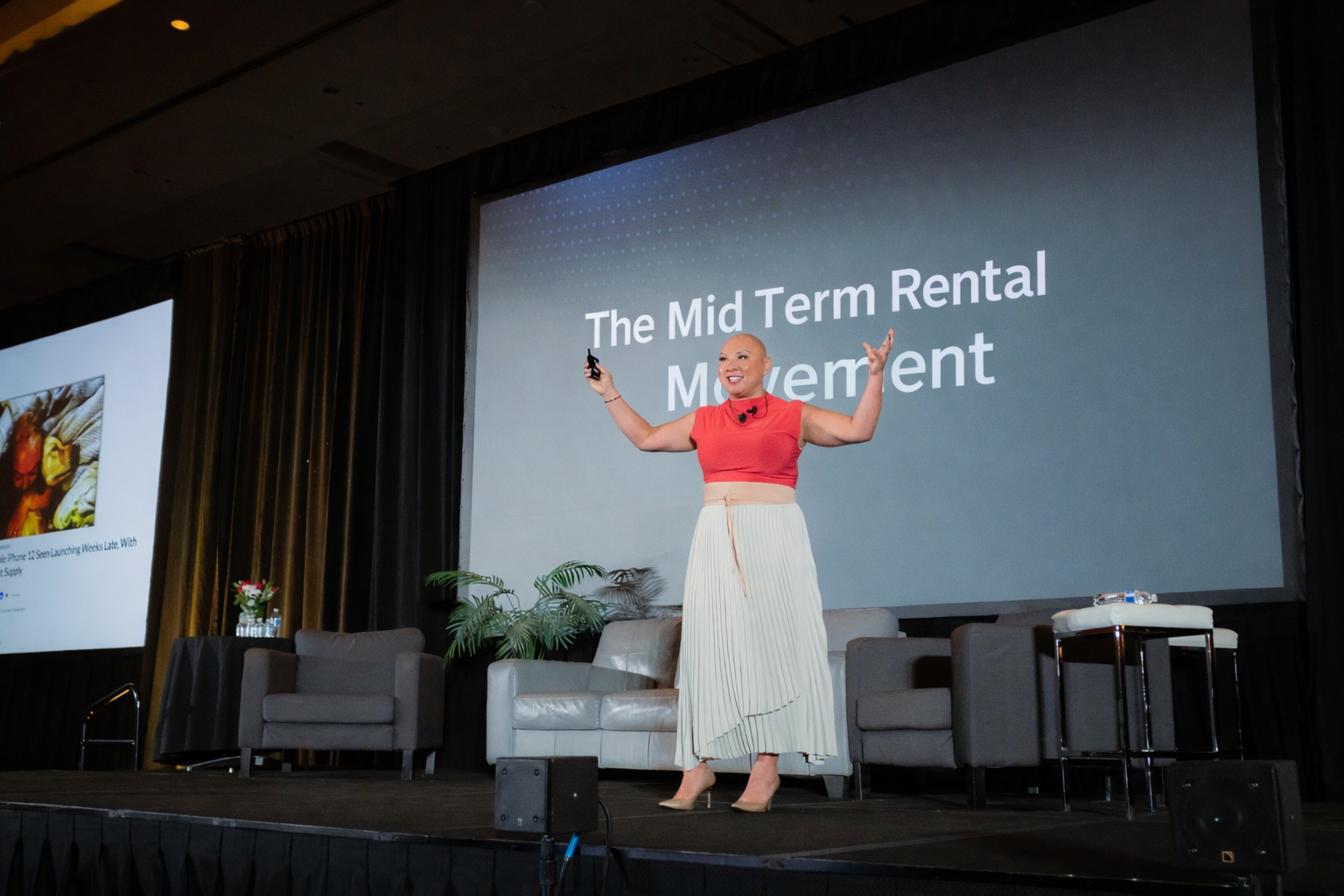 Vivian Yip speaking on stage in front of a Mid Term Rental Movement slide