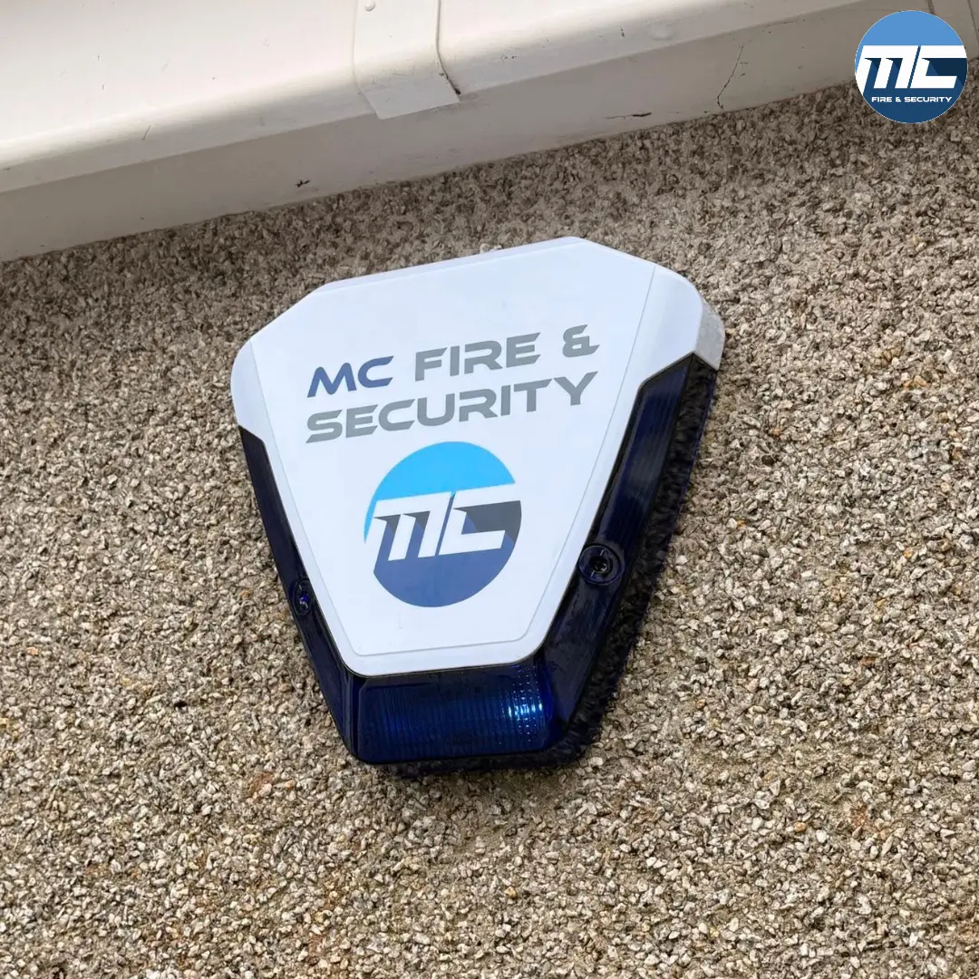 MC Fire & Security branded blue external sounder bell box — intruder alarm install