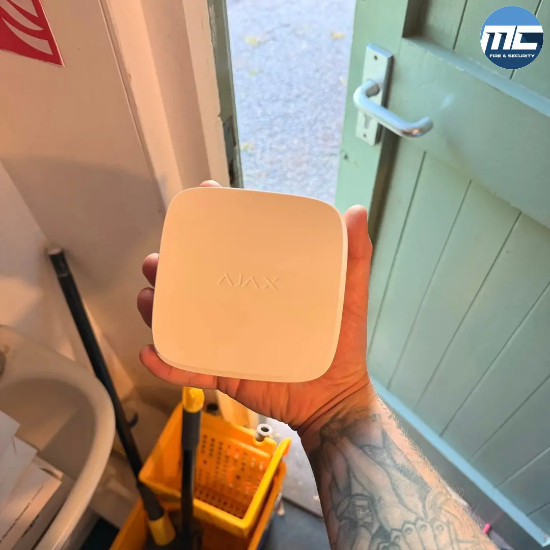 MC Fire & Security engineer holding an Ajax wireless intruder alarm sensor