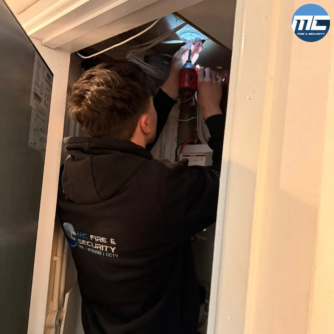 MC Fire & Security engineer installing intruder alarm overhead