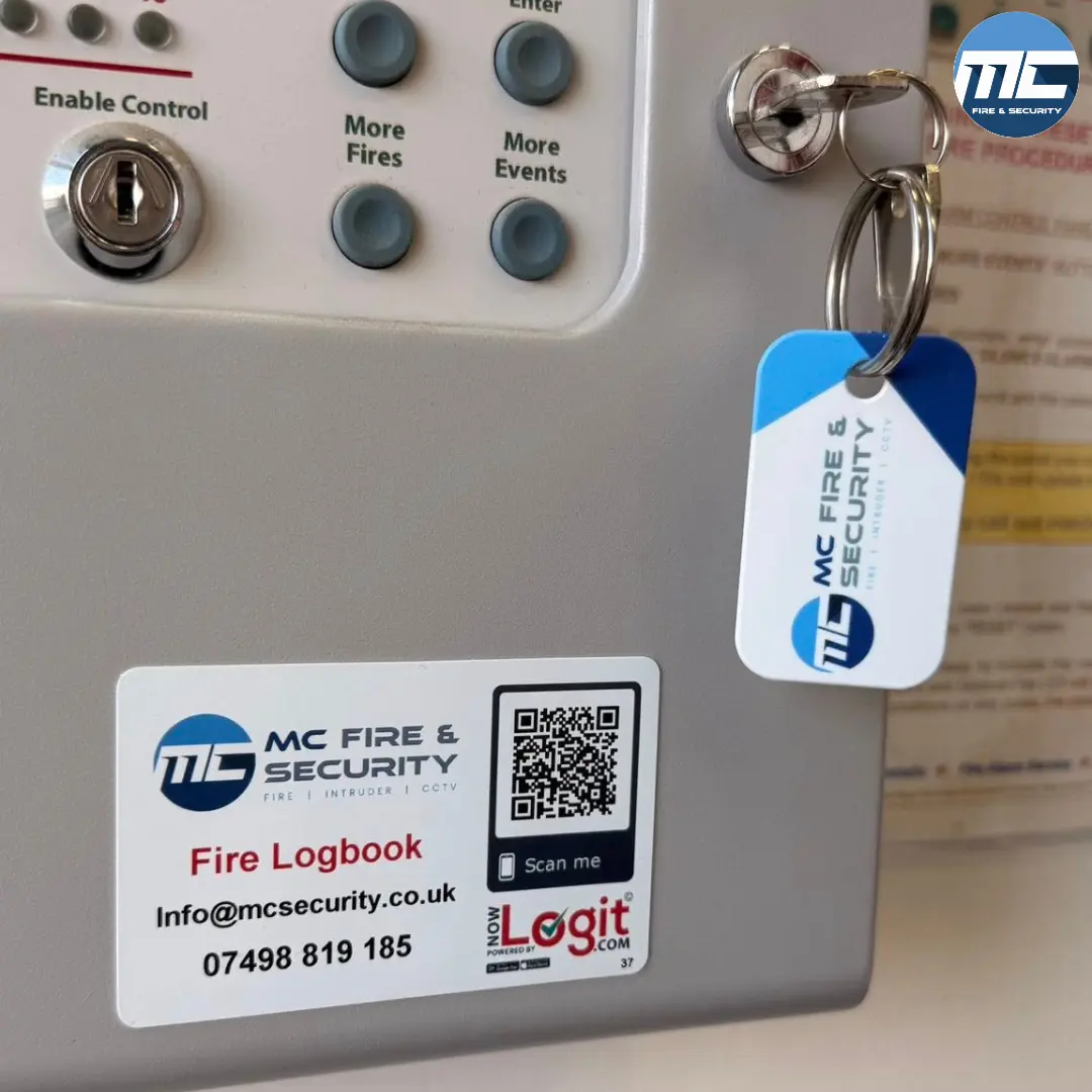 MC Fire & Security logbook sticker and branded keyholder tag — fire alarm takeover