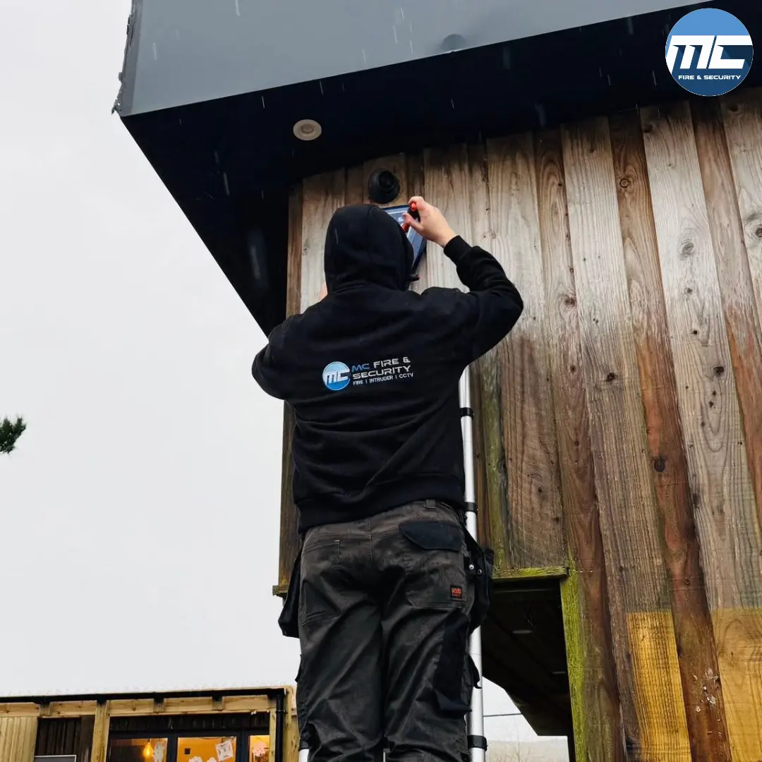 MC Fire & Security engineer working on the exterior of a Cornwall children's nursery building