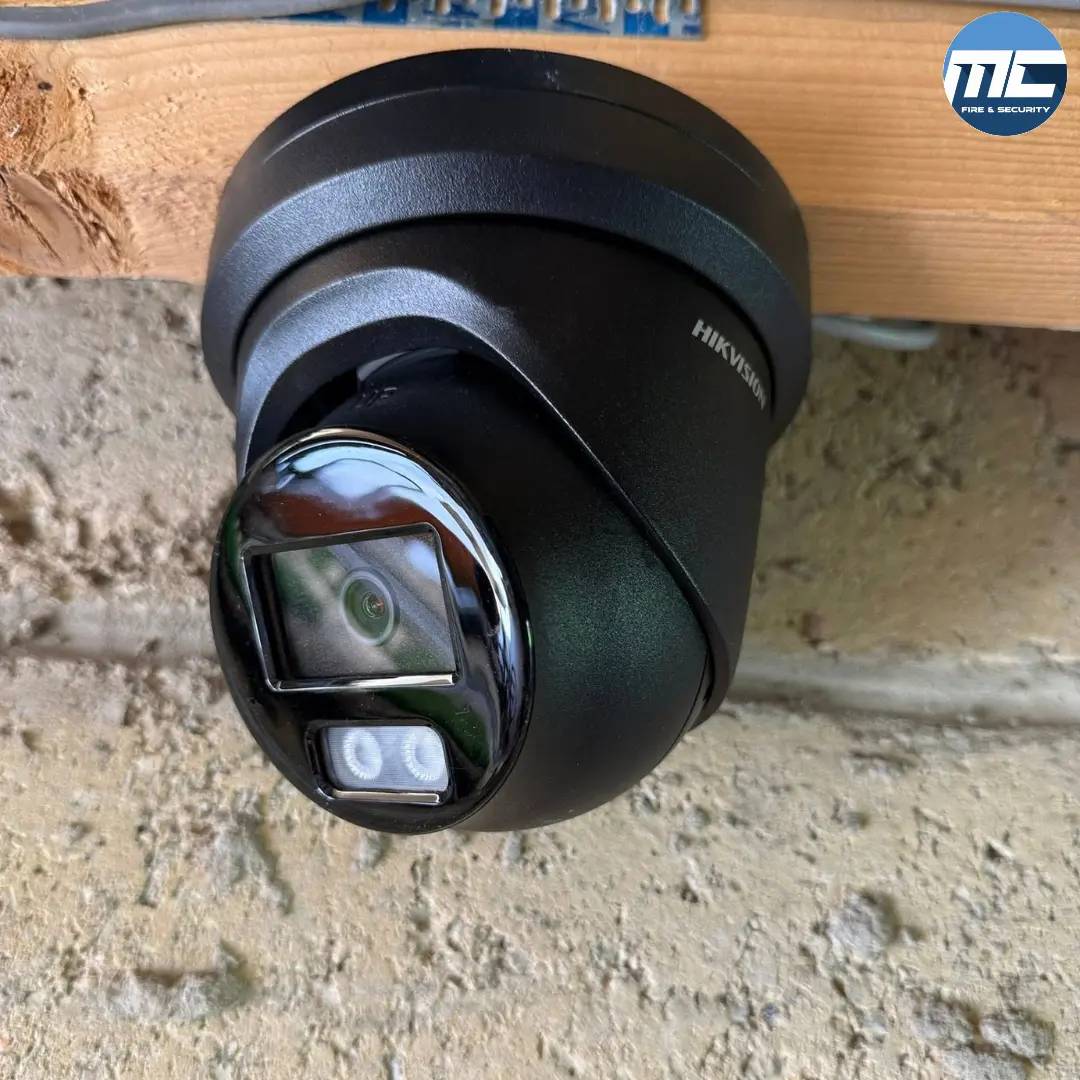 Close-up of black Hikvision turret CCTV camera under timber soffit