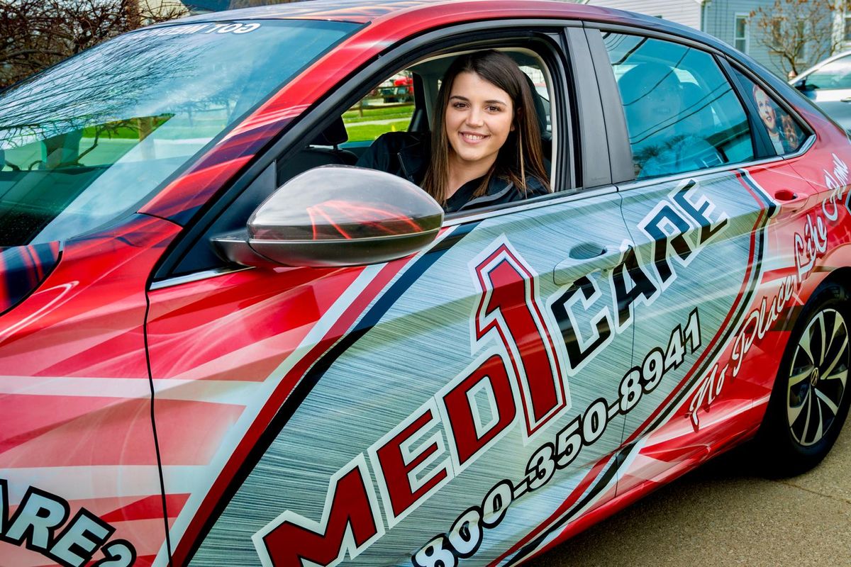 Med1Care team member in the red Med1Care company vehicle