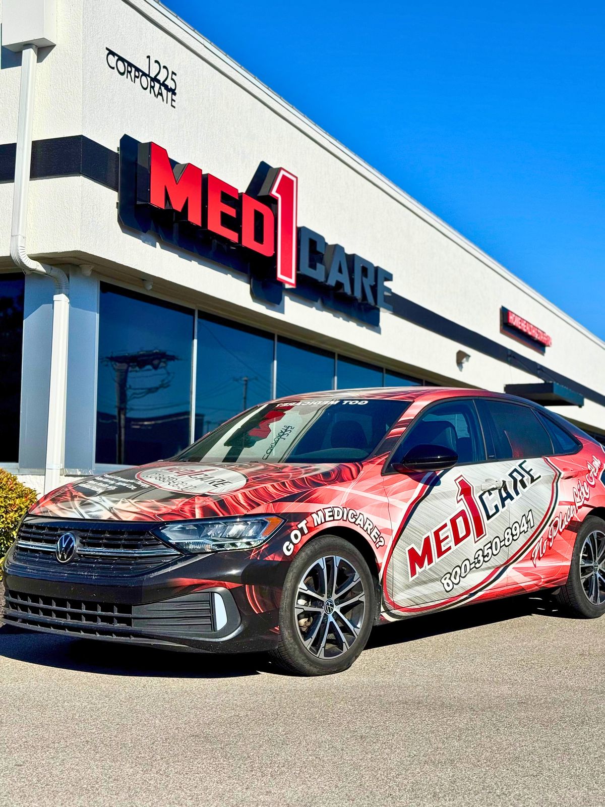 Med1Care Volkswagen Jetta with red fleet livery parked at the office