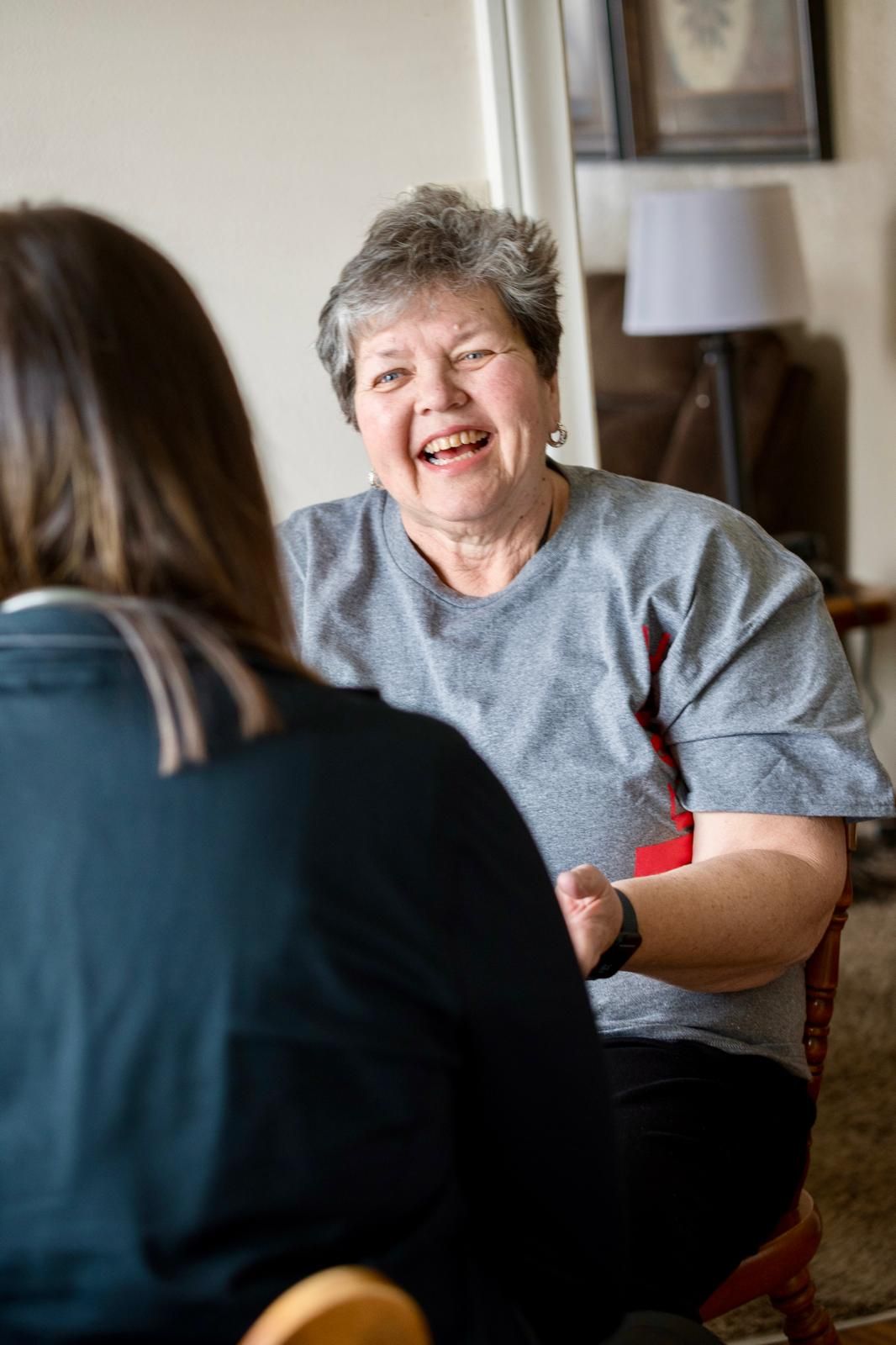 Med1Care caregiver visiting with a smiling client at home