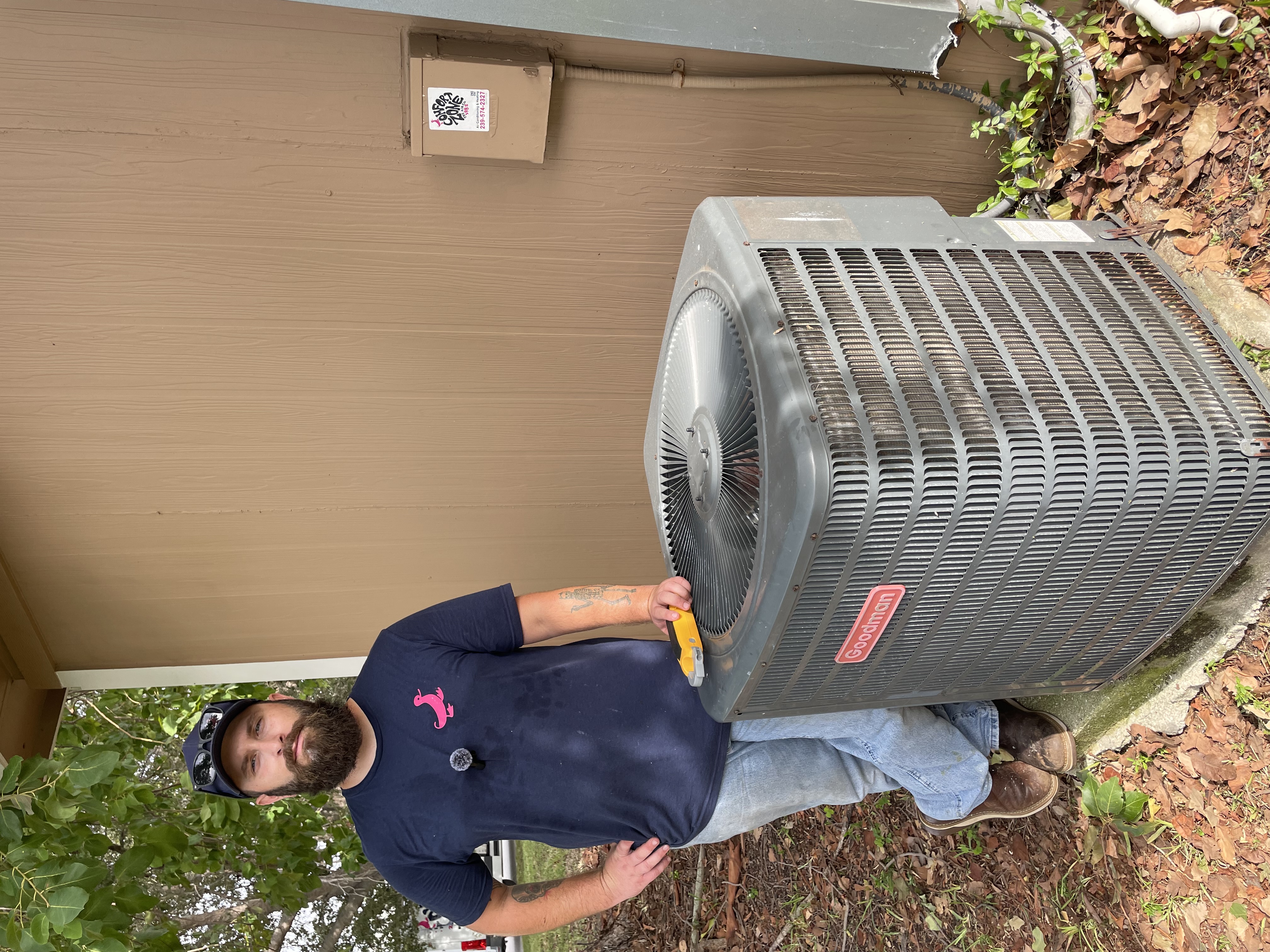 Comfort Zone technician beside an outdoor AC installation