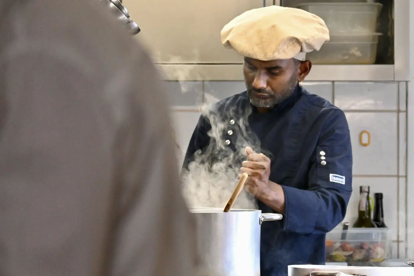 Cuoco al lavoro ai fornelli del Ristorante Tre Risotti