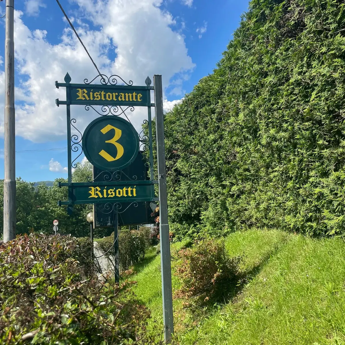 Insegna del Ristorante Tre Risotti tra il verde della Valganna