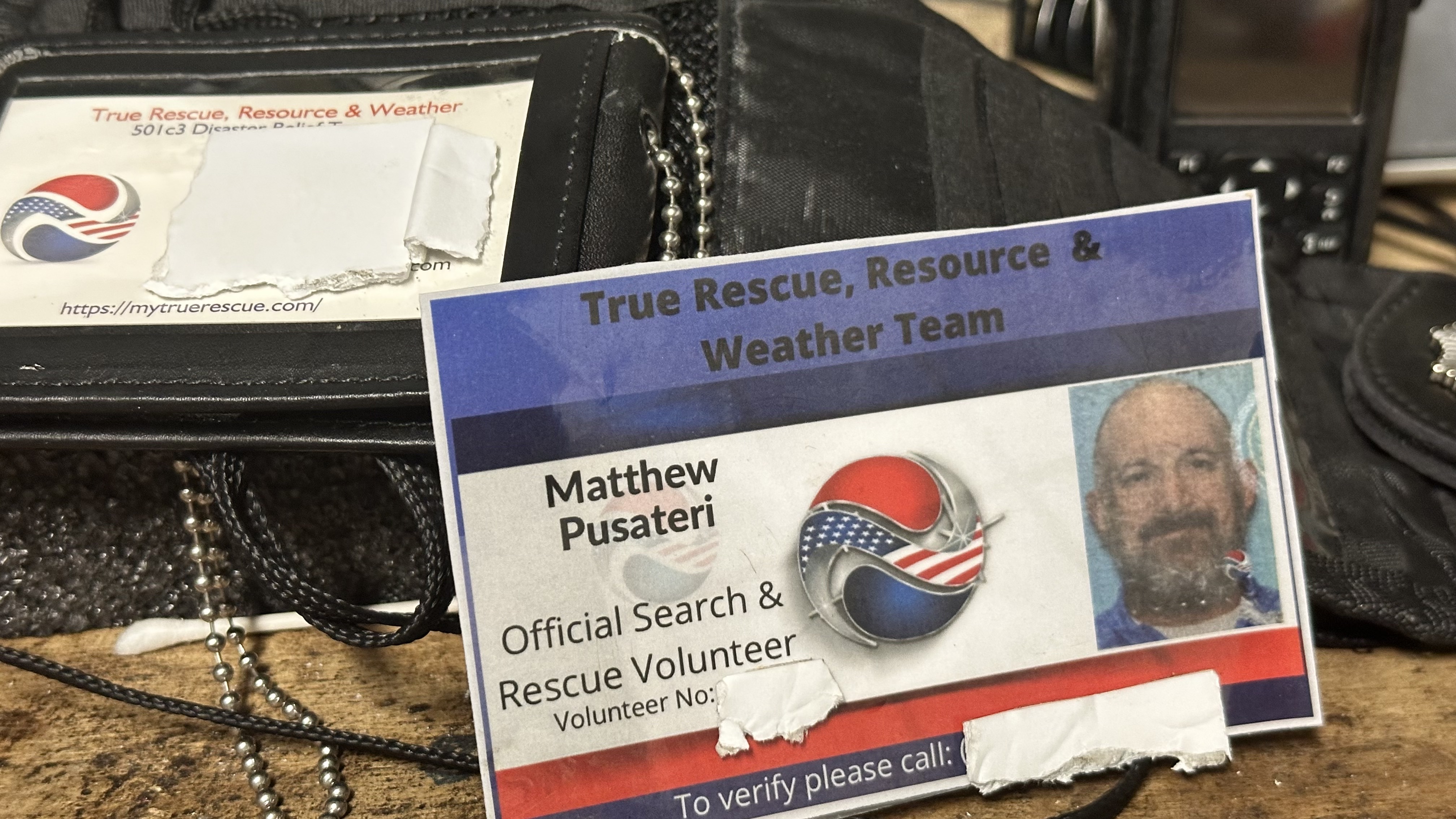 Official True Rescue volunteer credentials and field radio.