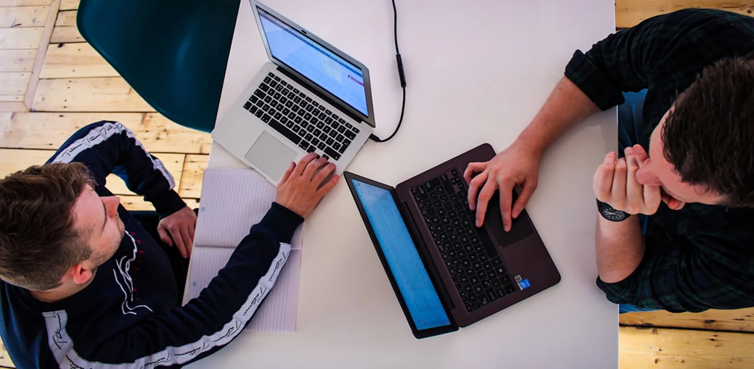 Two people working on laptops together