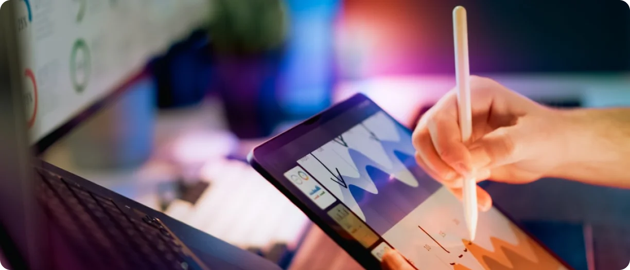 Person using stylus on tablet with data charts and analytics