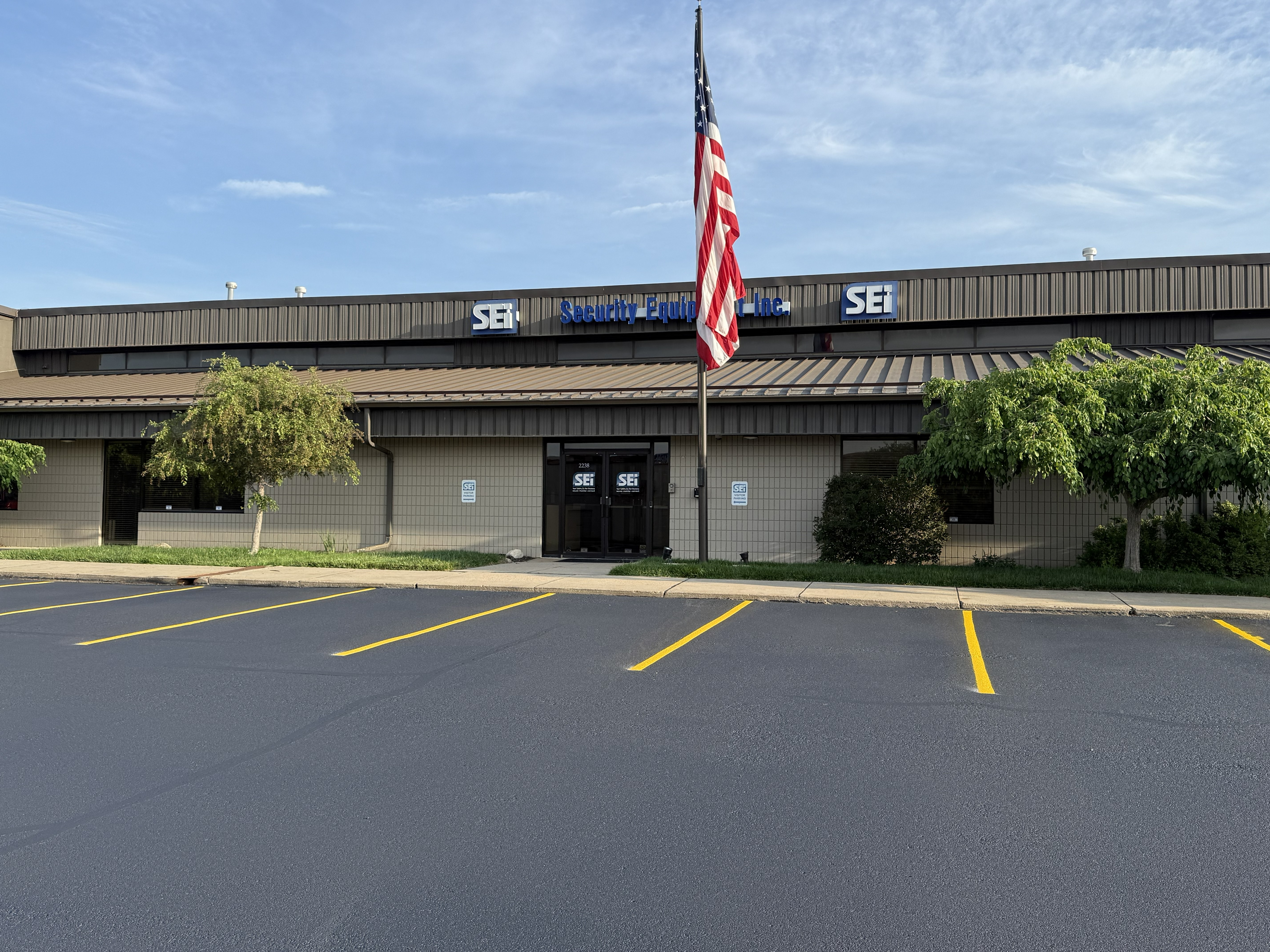 Freshly sealcoated commercial parking lot with new yellow line striping in front of office building