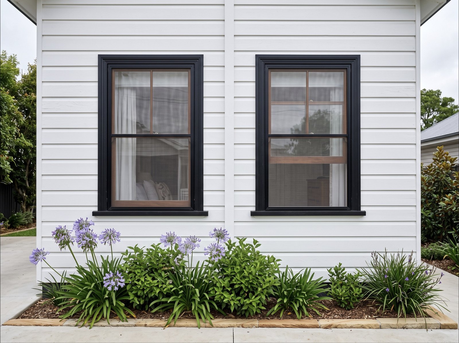 After: SecureView window screens in black frames on a weatherboard home