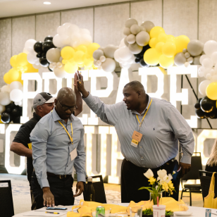 EQUIP real estate conference with 'PREPARE' sign and high five
