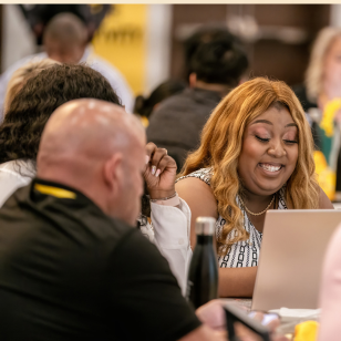 Excited woman on laptop at EQUIP real estate event