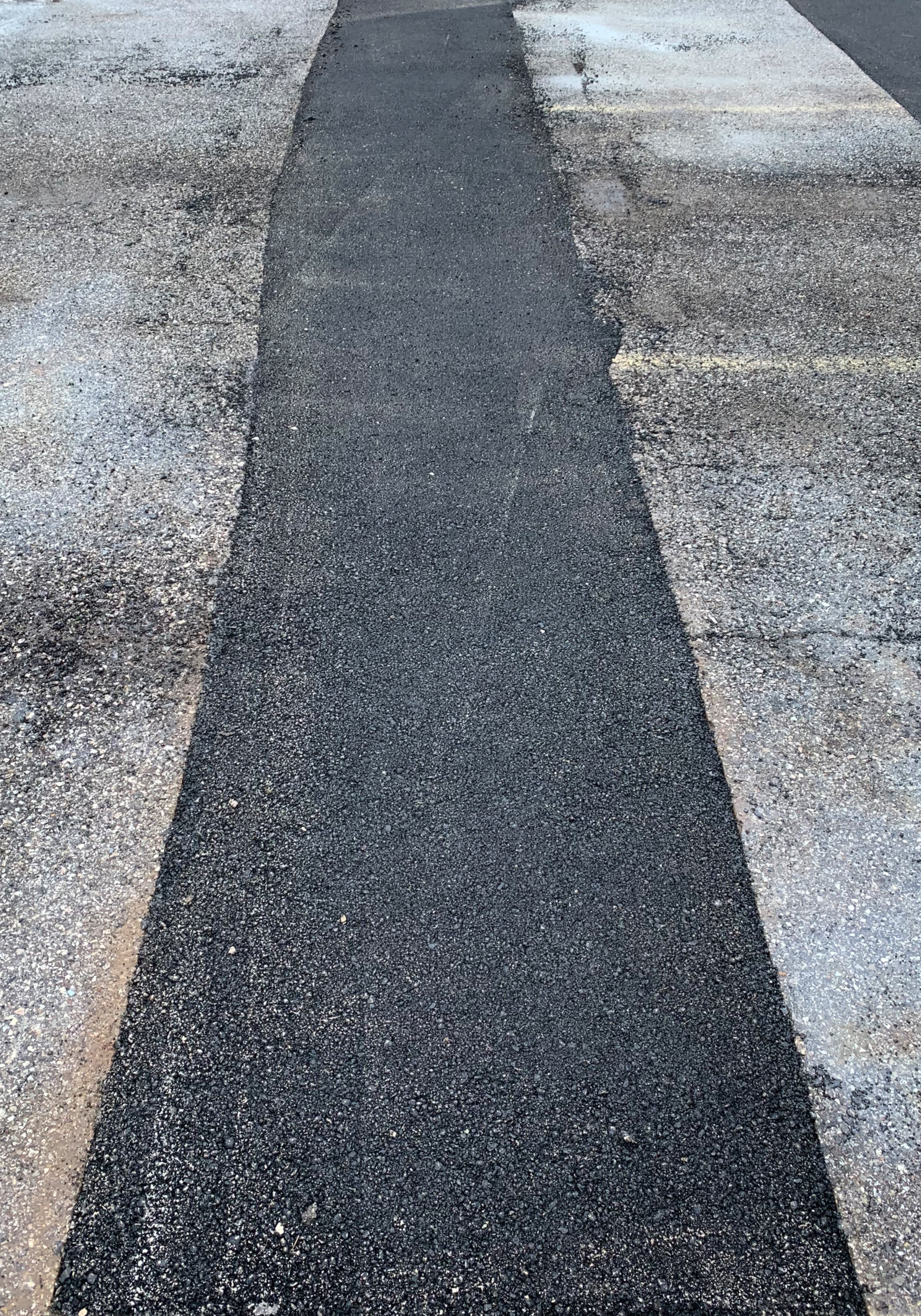 Old cracked asphalt driveway needing replacement