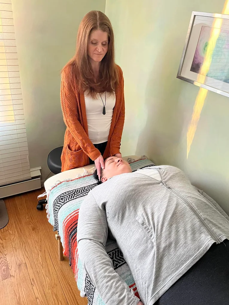 Jenna Galligani performing Reiki energy work, with hands placed gently at a client's head during a session at Holistic Awakenings in Allentown, PA