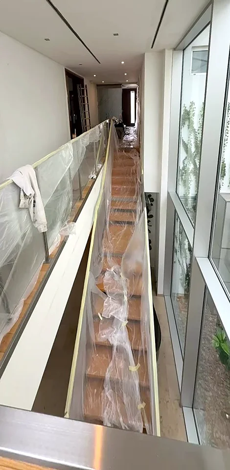 Schodiště a skleněné zábradlí zakryté fólií