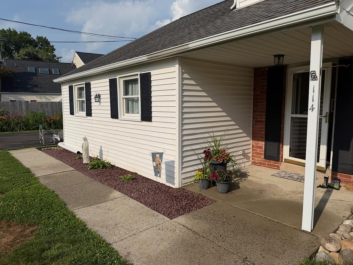 Front elevation of a Hatboro, PA home after a full house wash, siding bright white against a blue sky