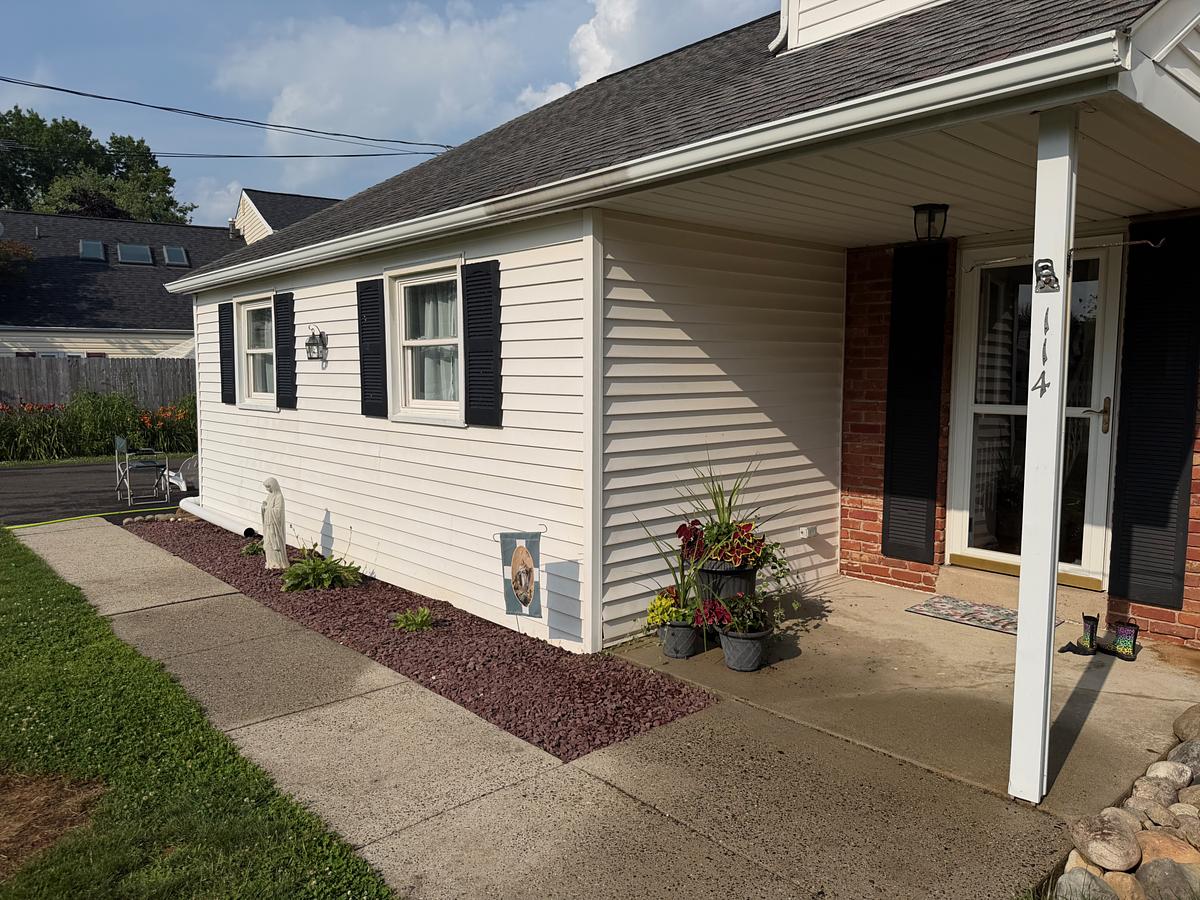Soft-washed white siding and black shutters on a Hatboro, PA home, walkway and entry clean