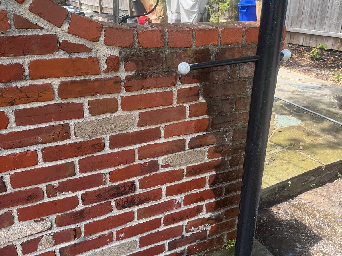 Red brick garden wall after pressure washing, mortar clean and the brick color restored