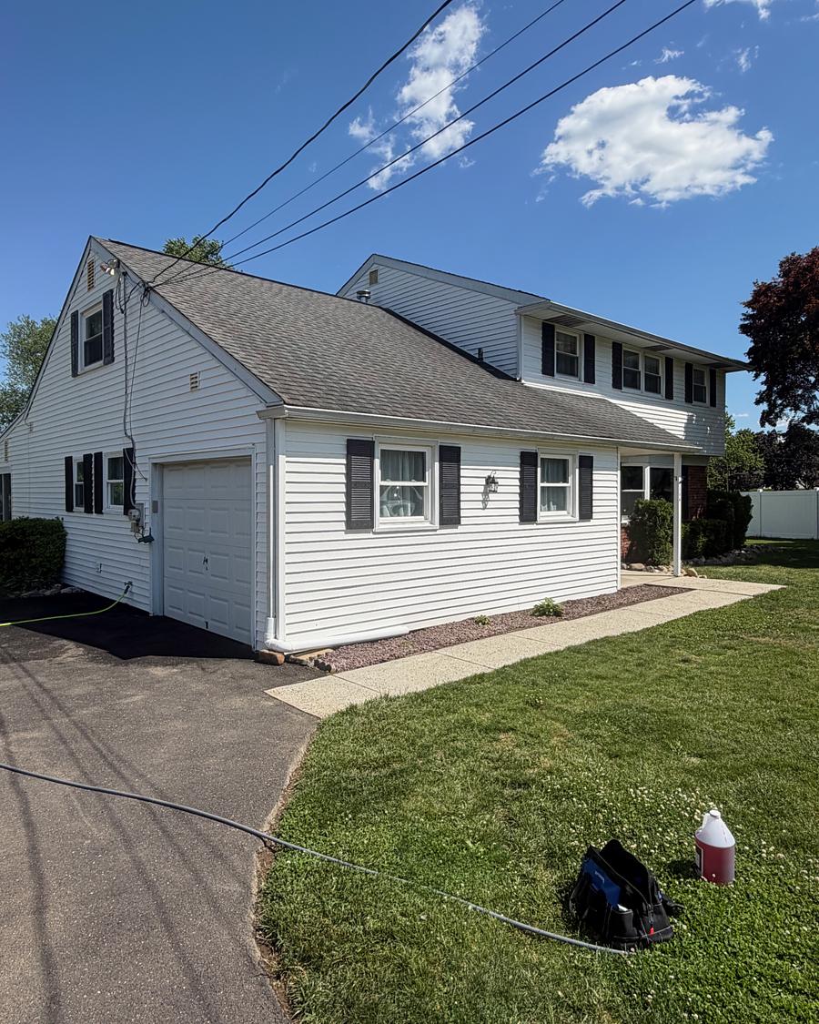 Clean concrete walkway curving across a lawn to a washed white home in Hatboro, PA