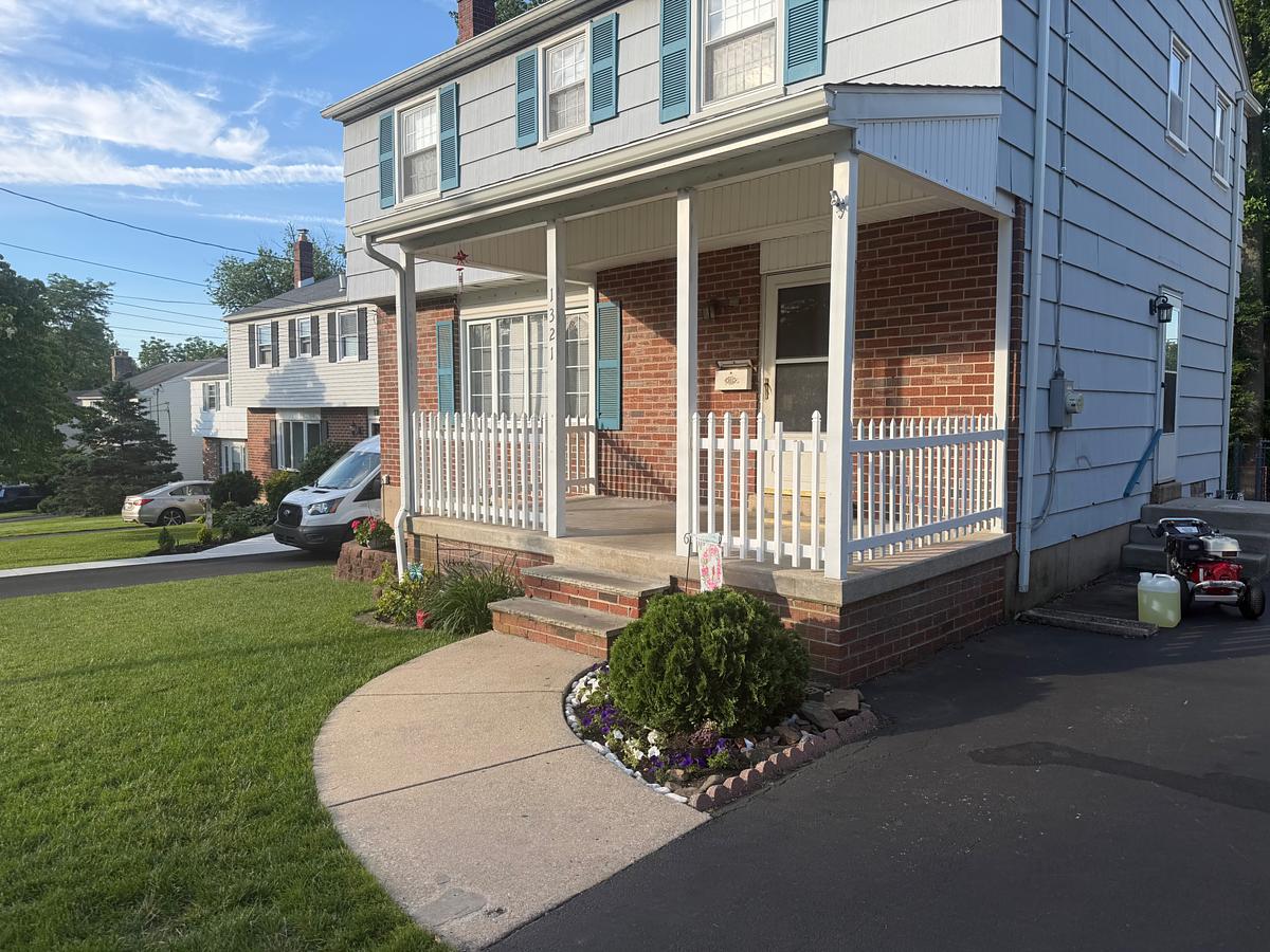 Washed concrete walkway and brick steps at the front door of a Havertown, PA twin home