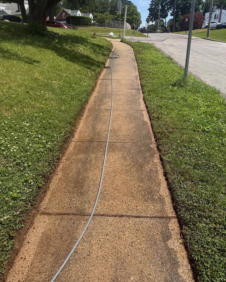 Long concrete front walkway in Havertown, PA before washing, stained an uneven tan and brown