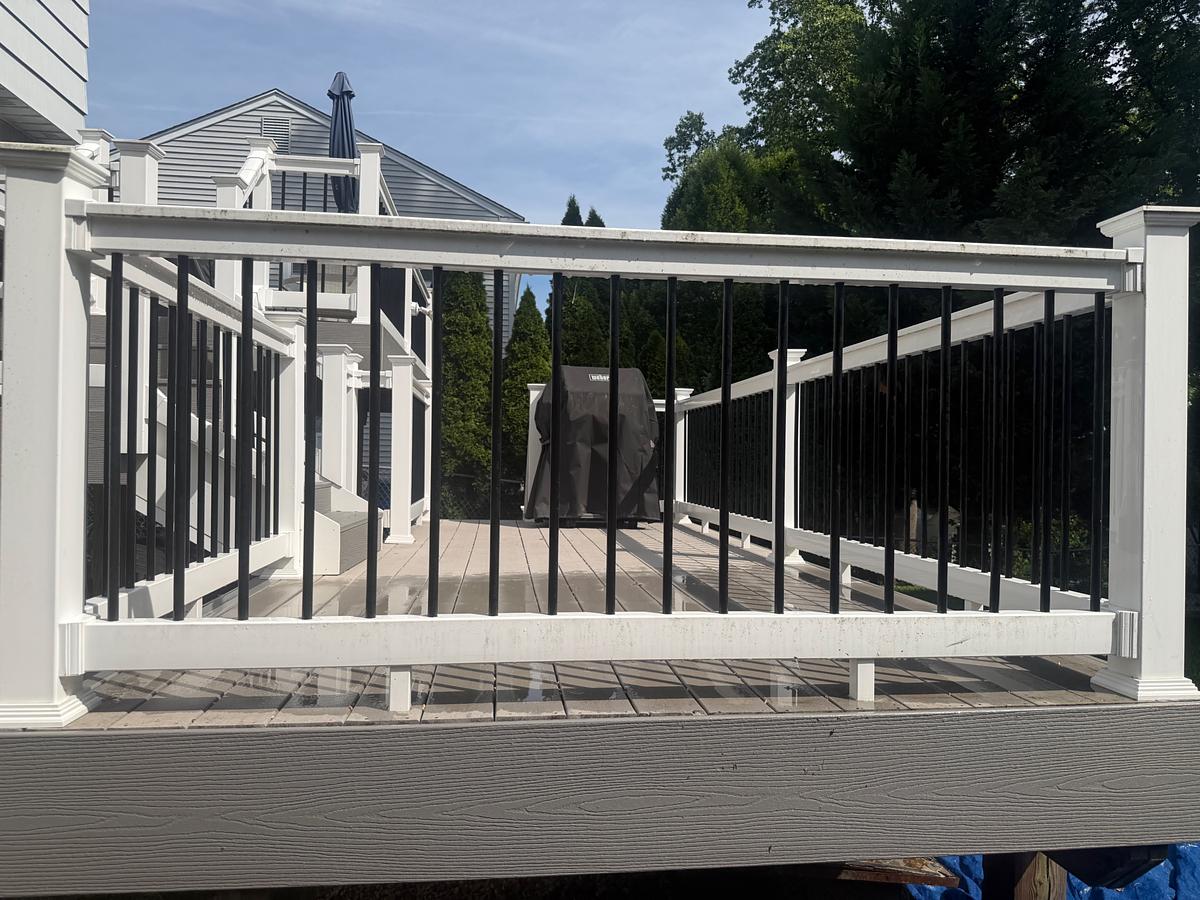 Clean composite deck boards and white posts on a raised Havertown, PA deck after washing