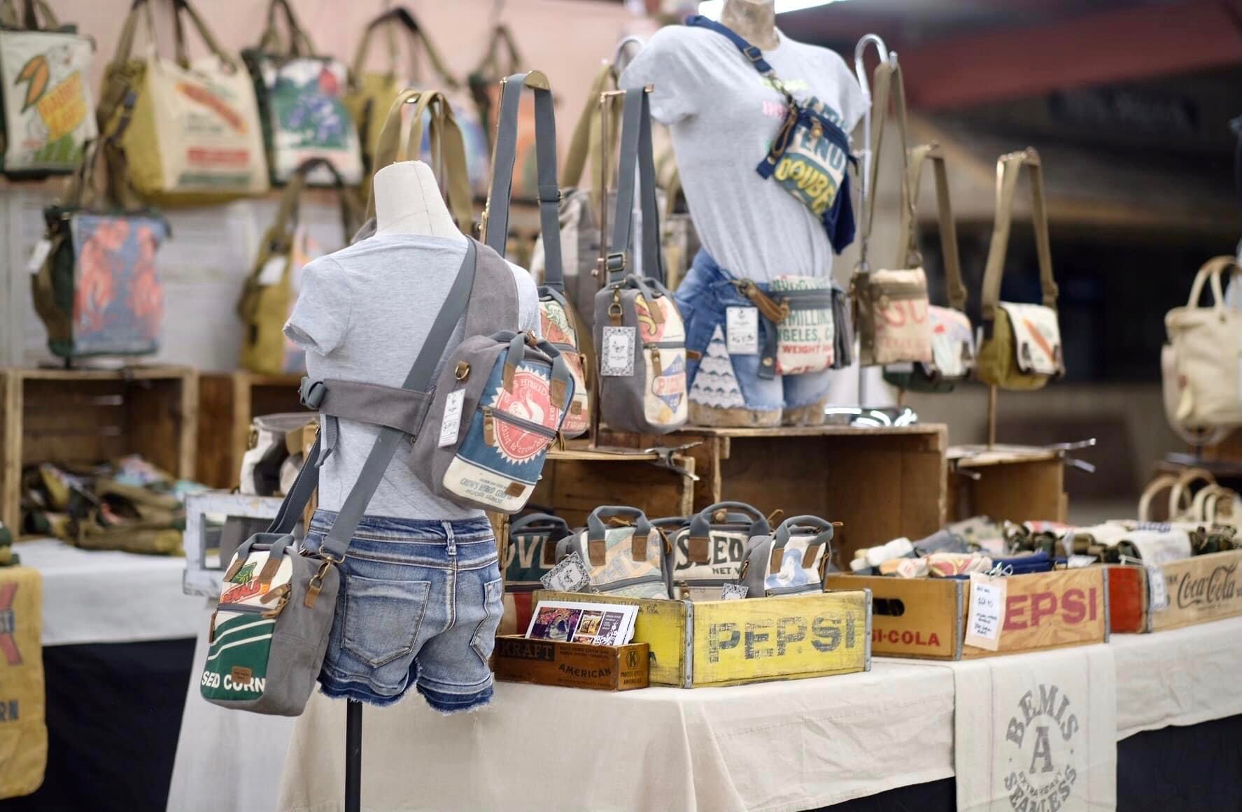 Curated market booth setup with vintage-style bags and accessories