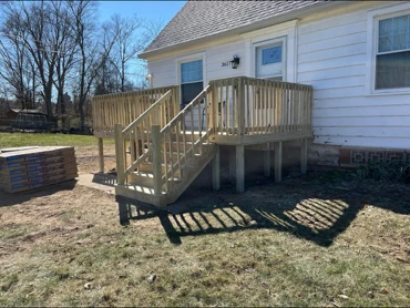 Raised deck and stairs on a white-sided home