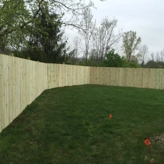 Wood privacy fence along a treeline