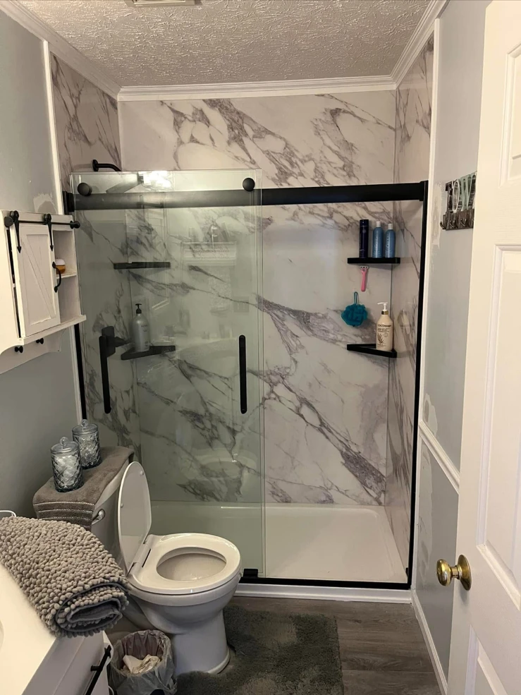 Marble-look shower with black sliding doors