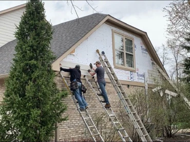The crew re-siding a gable end