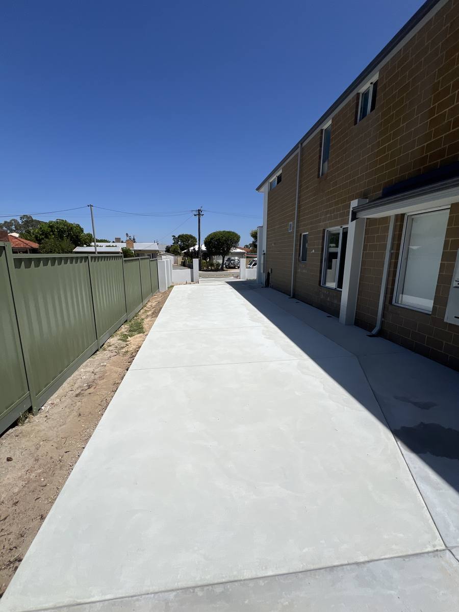 Finished plain concrete driveway alongside a Perth home