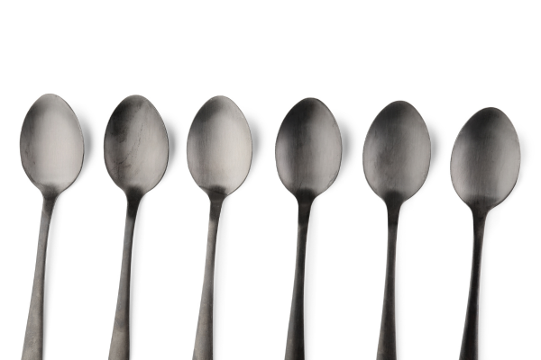 Six dark gray spoons are arranged in a line against a white background. Representing units of energy according to the Spoon Theory.