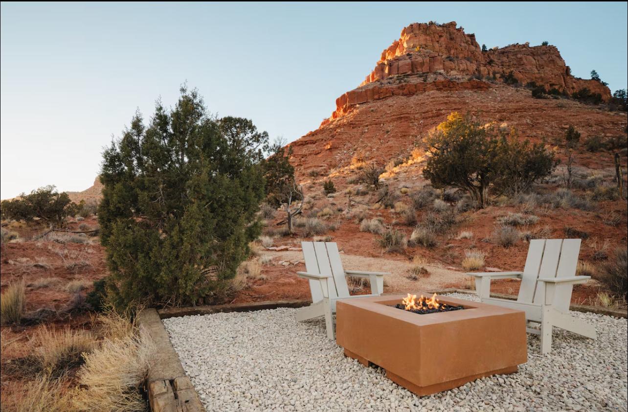 A firepit overlooking a red rock canyon at sunset