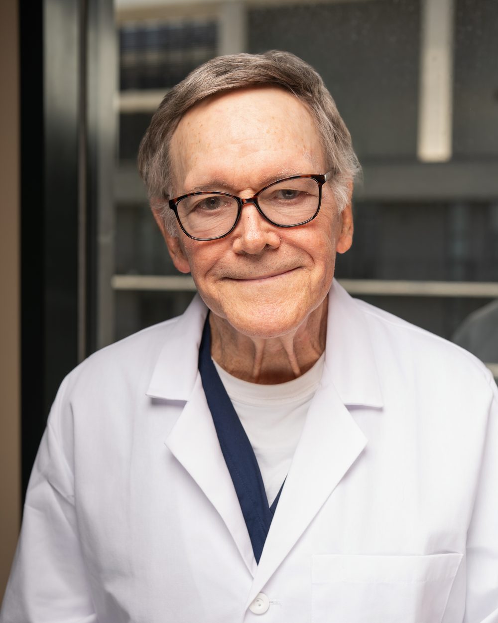 David Cheesman, DO, board-certified osteopathic physician, in a white coat