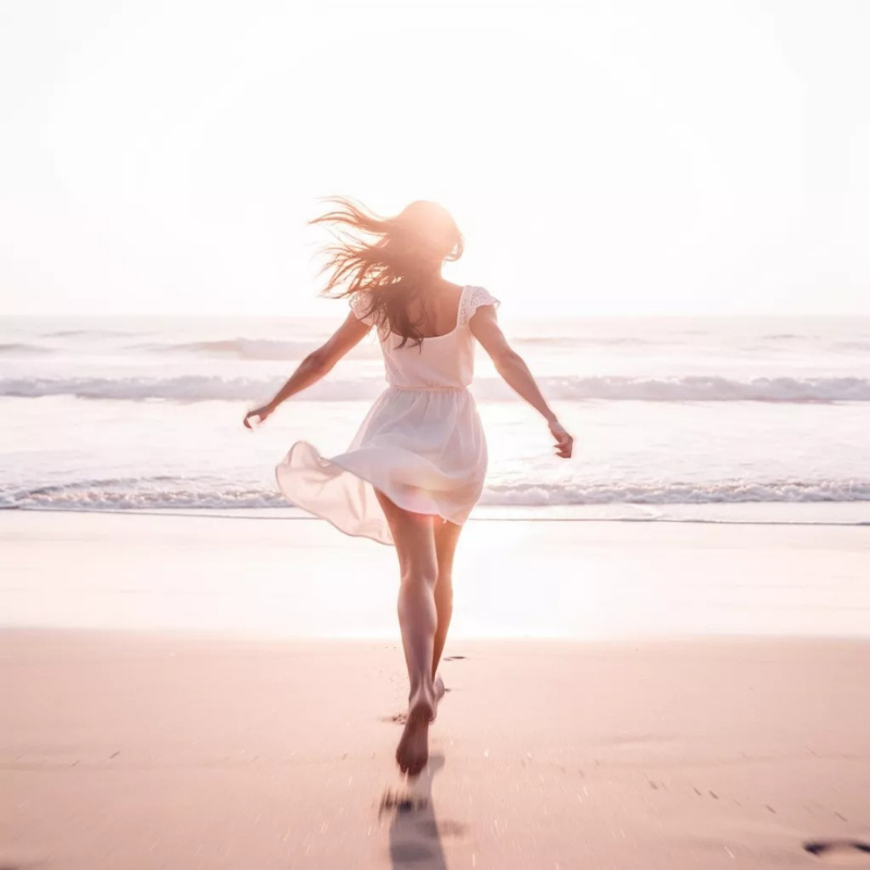 Woman walking on the beach feeling free