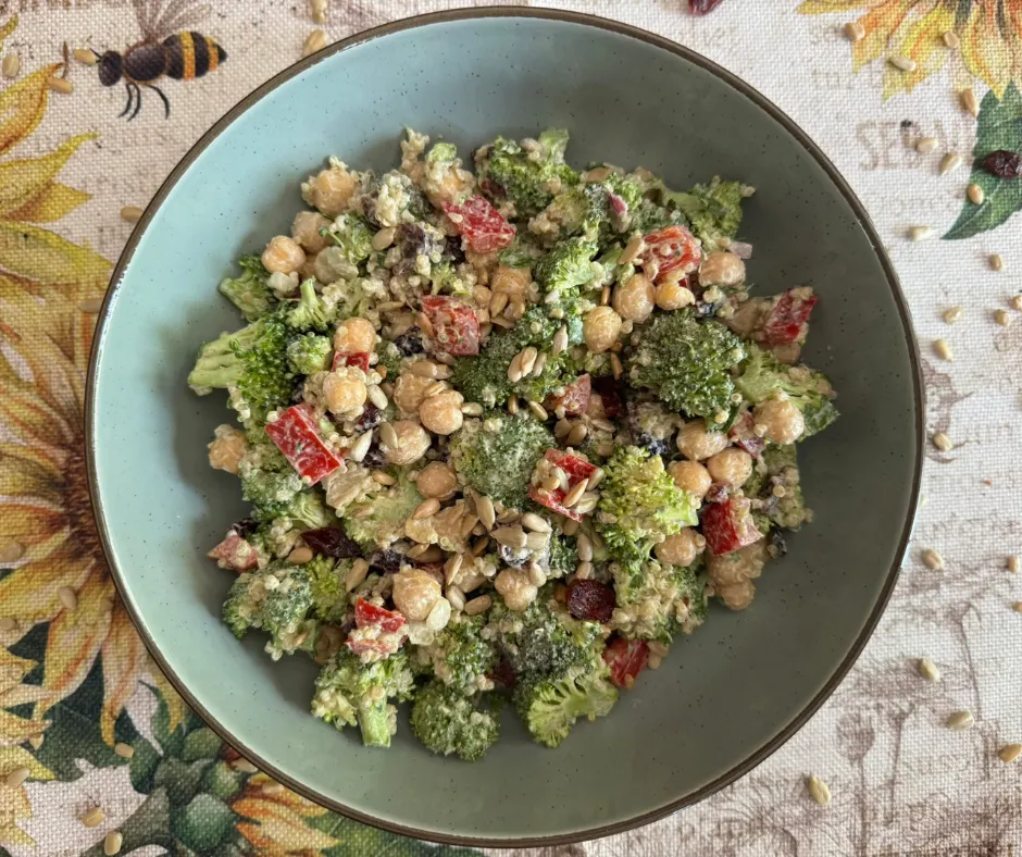 Broccoli quinoa meal-prep salad with chickpeas, quinoa, red bell pepper, dried cranberries, parsley, and sunflower seeds.