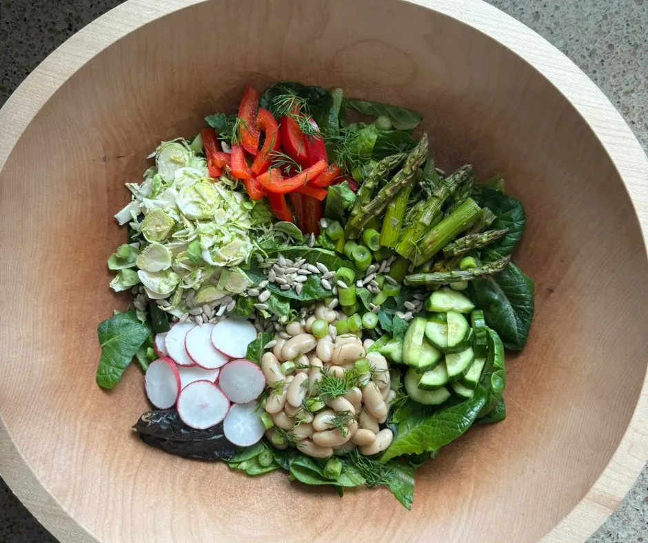 Example of a Salad of the Week bowl with leafy greens, vegetables, and plant-based toppings