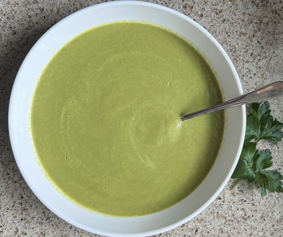Bowl of creamy broccoli herb soup garnished with fresh parsley