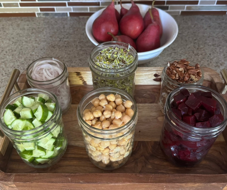 Prep-ahead ingredients for Pear and Beet Garden Bowl in jars with red pears in a bowl