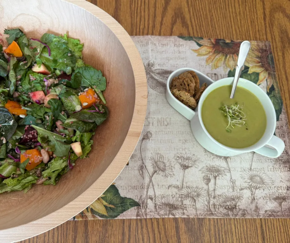 Winter Harvest Bowl served with creamy broccoli herb soup and crackers on a wooden table