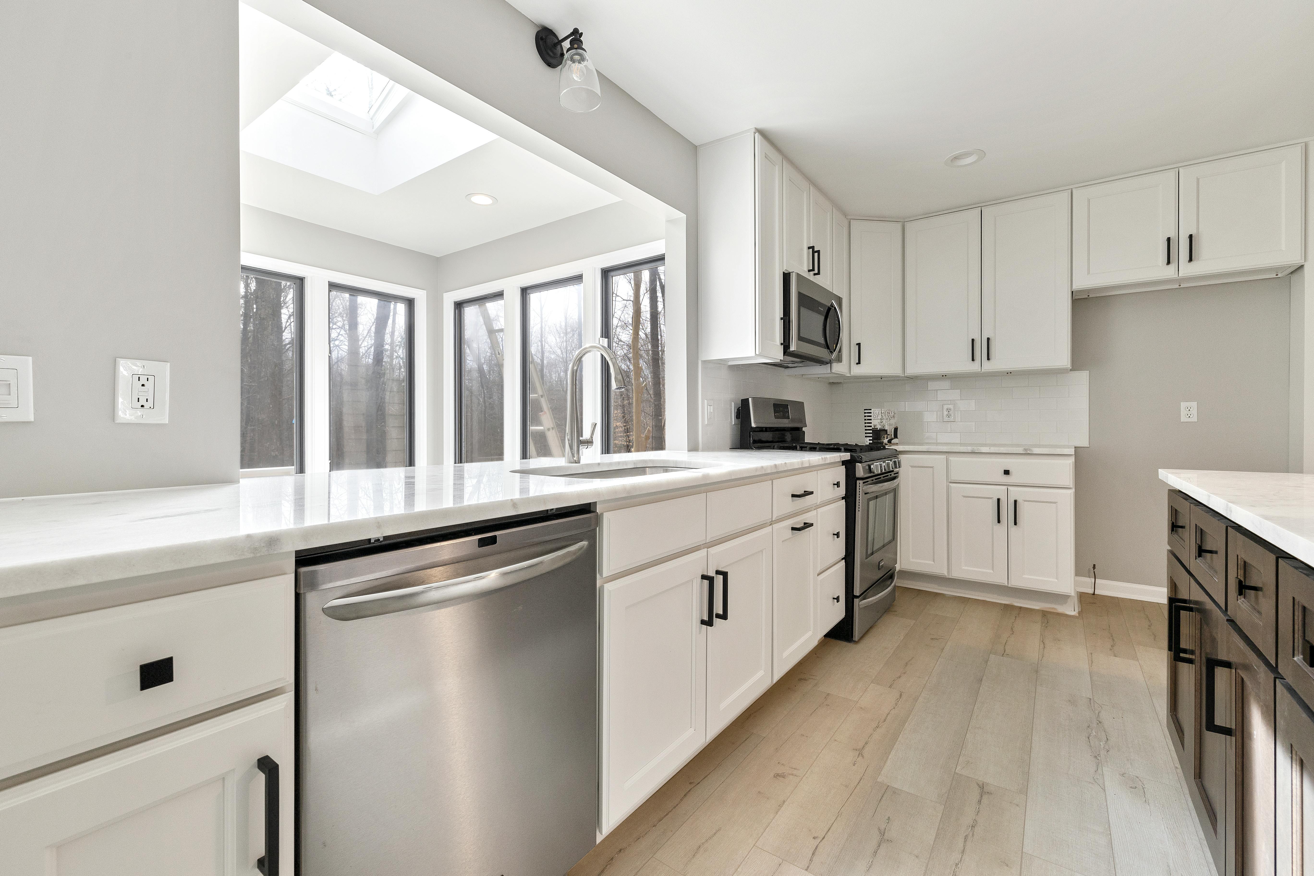 Home remodeler renovating a modern kitchen with cabinetry and tools