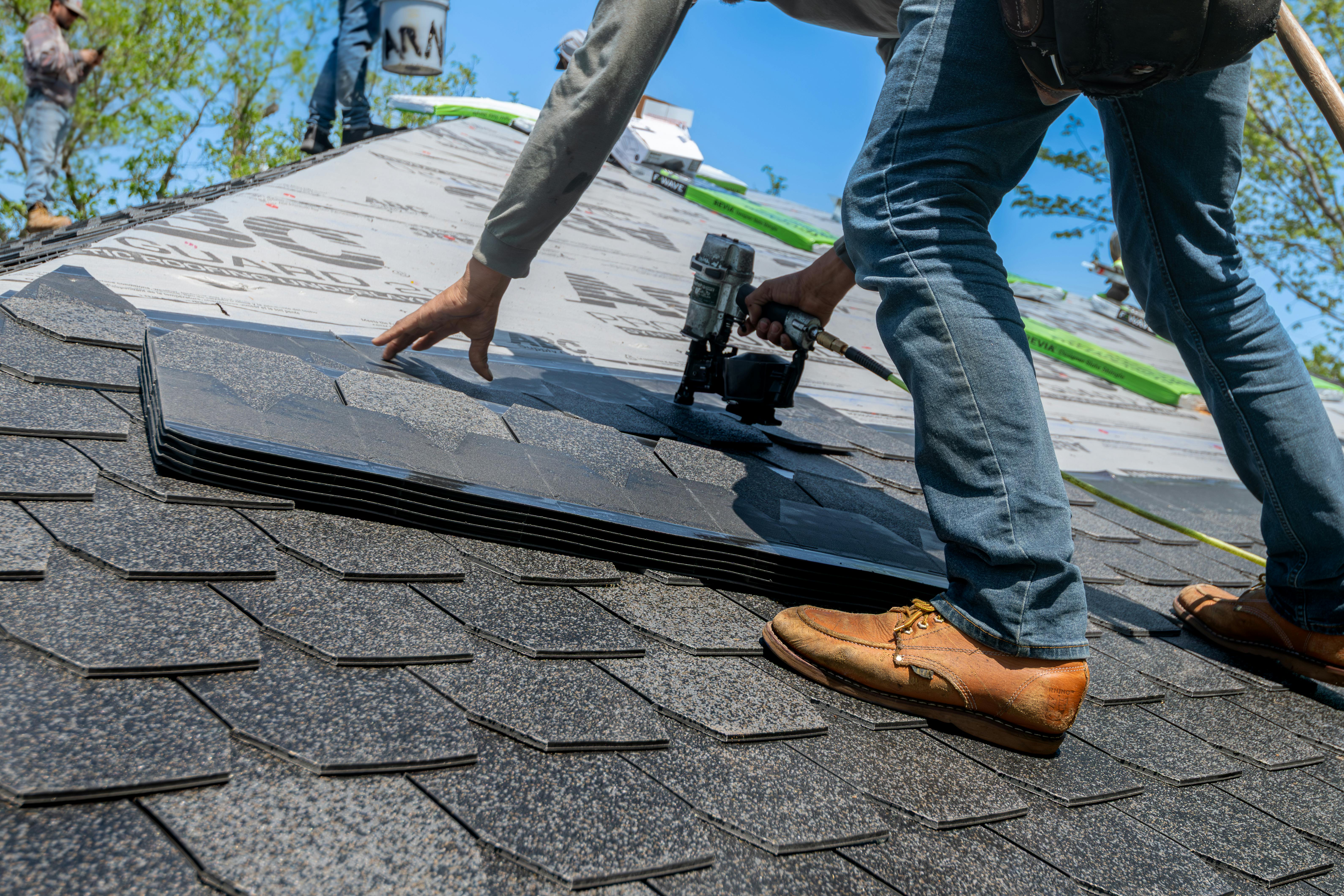 Professional roofer installing shingles on a residential roof