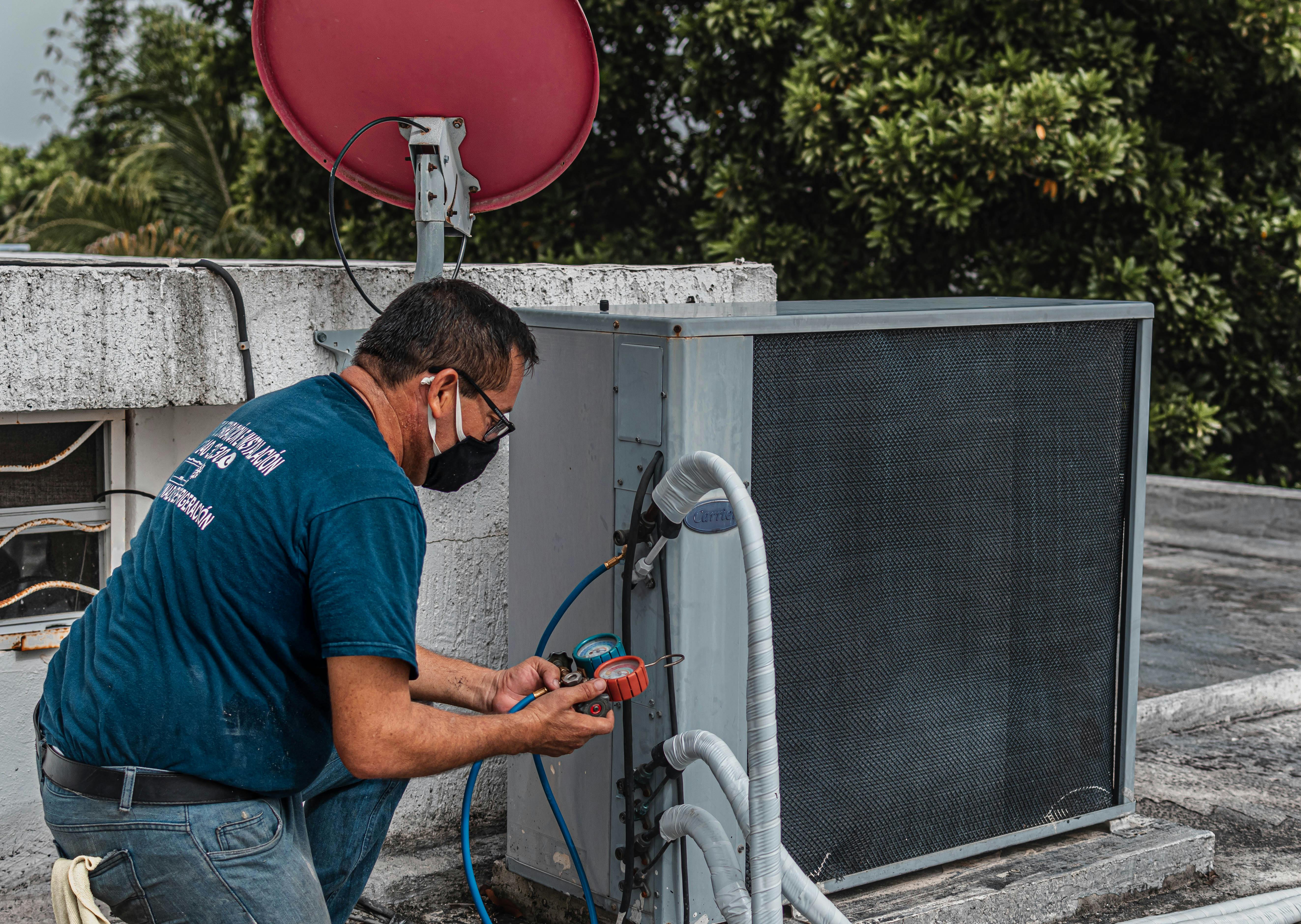 HVAC technician servicing an air conditioning unit in a residential home